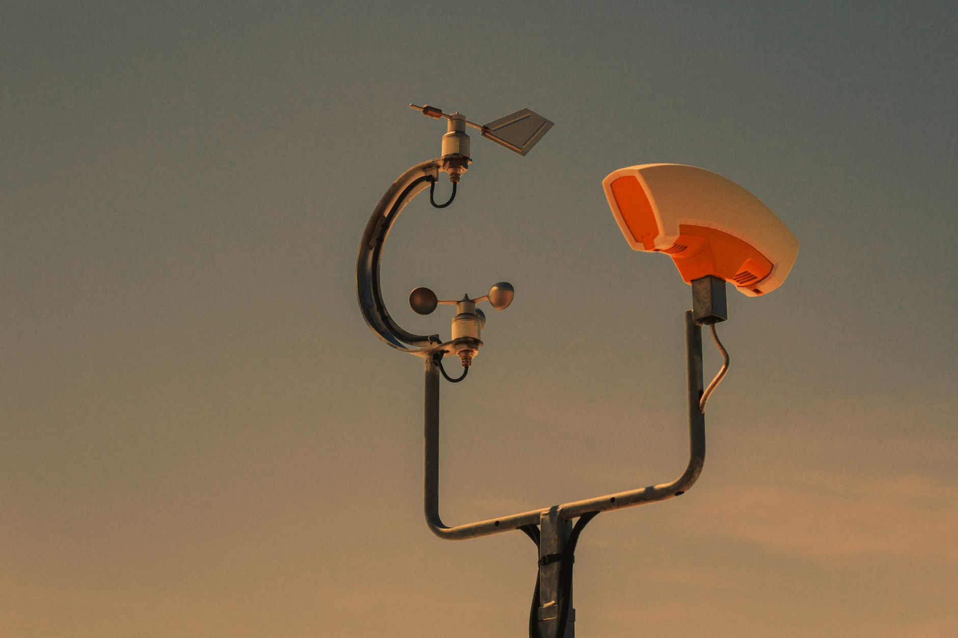 A professional weather station setup in an open grassy landscape.