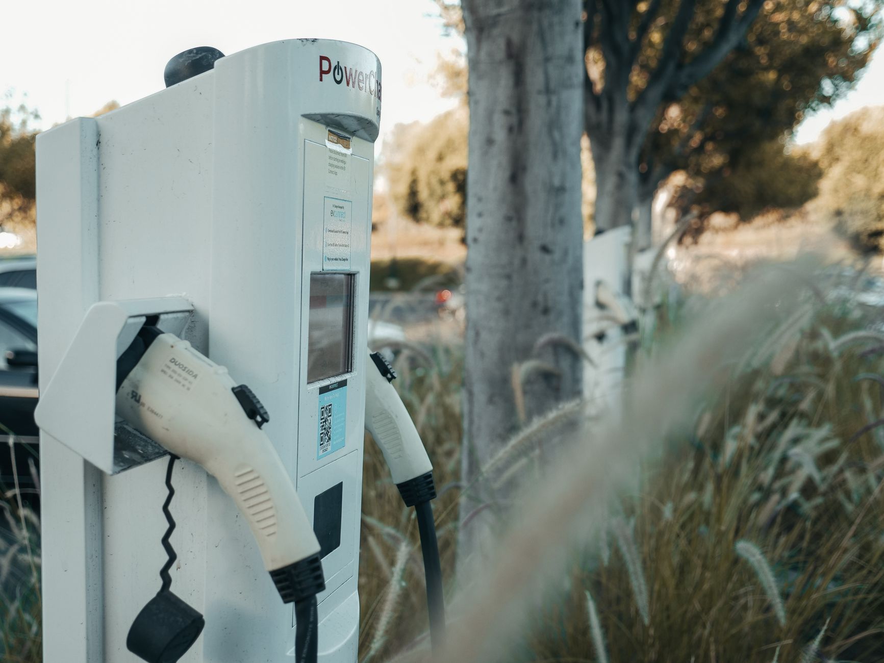 An electric vehicle charging station set against a wide California landscape.