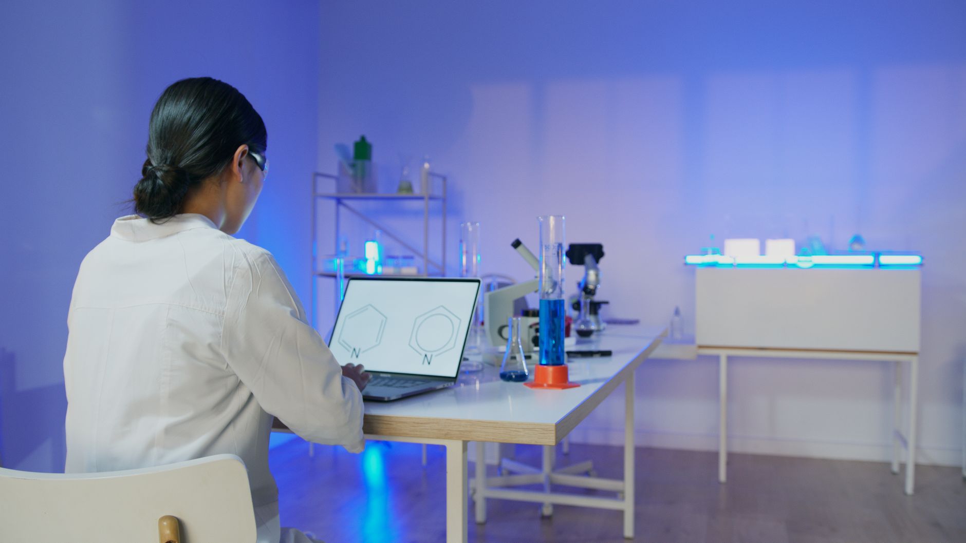 A researcher working on a laptop in a laboratory